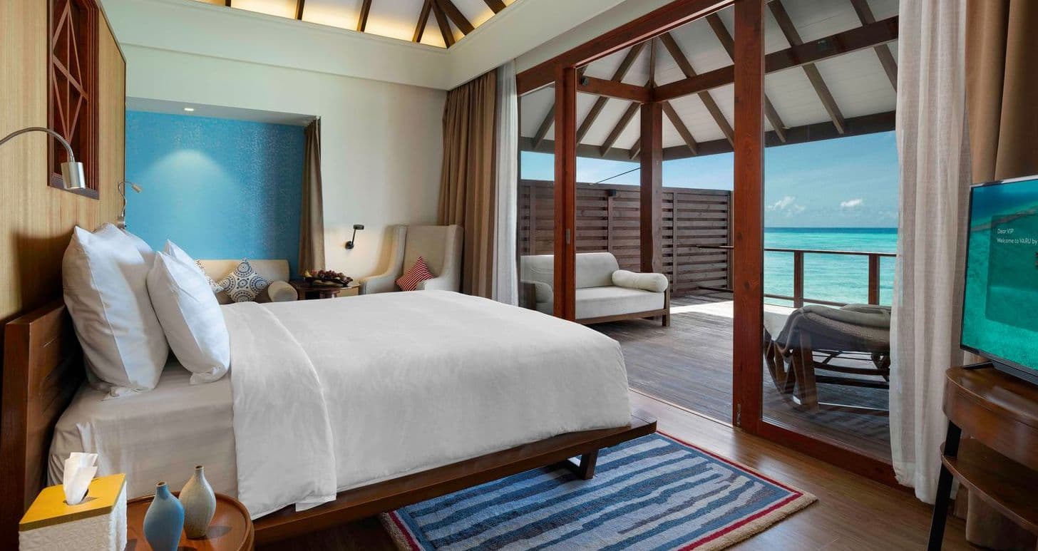 A bathroom with a bathtub and a bathtub on a deck overlooking the ocean.